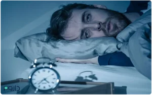 مردی که دچار بی‌خوابی است، شب‌هنگام با چشمان باز در تخت دراز کشیده