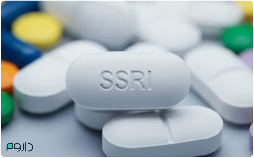 قرص سفید با نوشته SSRI در میان چند قرص رنگی؛ نمادی از داروهای ضدافسردگی مهارکننده بازجذب سروتونین.
